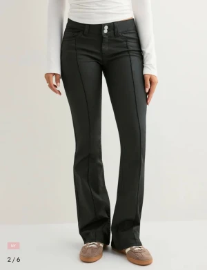 Svarta bootcut byxor med låg midja  - Snygga svarta bootcut byxor från Nelly lite läder liknade 