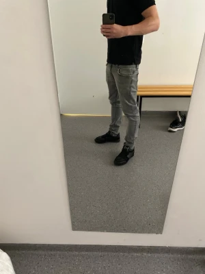 Nudie jeans  - Säljer ett par grå jeans med skinny fit och normal passform. Byxorna har klassisk femficksdesign, dragkedja och knapp i midjan. Jeansen är tillverkade i stretchigt denim som sitter tajt längs benen och har en snygg, ljusgrå tvätt.