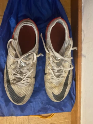 Nike fotbollsskor i beige och orange - Säljer ett par Nike fotbollsskor. Skorna har använts och är rätt slitna men håller fortfarande hög kvalité 