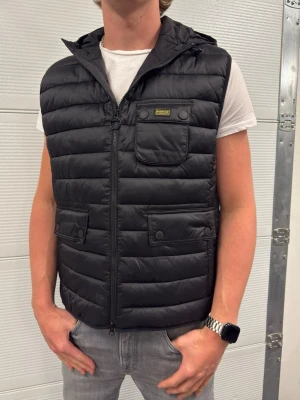 Barbour international väst  - En snygg väst från Barbour international i väldigt fint skick använd några gånger! Storlek XL. Hör av er vid frågor! Modellen är 188 och väger 77kg (passar större) 