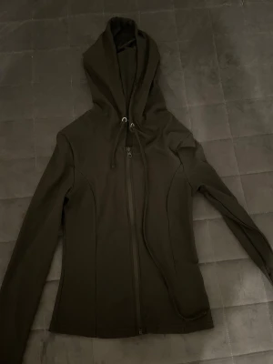 Tränings kofta - En skön svart tränings kofta med luva och band. Super stretchig. Koftan är helt ny, använt den ungefär 3 gånger. 