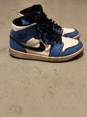 Nike Air Jordan 1 blå och vita - Säljer mina Air Jordan 1, dem har legat i källaren länge och behöver bli av med dem, dem är lite creasat där framme men annars så ser dem bra ut. Kan sänka priset endast vid snabb affär.