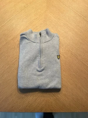 Half zip från lyle &scott - Säljer en grå half zip tröja från Lyle & Scott i merinoull. Använd väldigt lite och i väldigt bra skick, 9/10. Hör av er om ni har mer frågor!