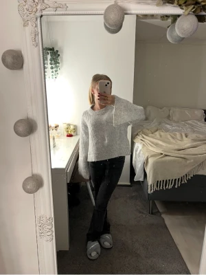 Ljusgrå stickad tröja från Gina Tricot - Supermysig ljusgrå stickad tröja från Gina Tricot. Tröjan har en relaxed fit med breda ärmar och ribbade detaljer vid halsringning, ärmslut och nederkant. Perfekt att slänga på sig när det är kyligt ute!