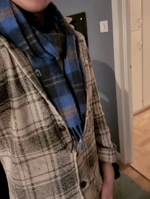 Rutig overshirt i beige och grå - Säljer en snygg rutig overshirt från H&M i beige och grå toner. Jackan har klassisk krage, knappar framtill och långa ärmar med knapp vid ärmslut. Perfekt lager på lager-plagg för dig som gillar avslappnad stil.