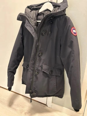 Marinblå jacka  från Canada Goose i fint skick !  -   Canada Goose Marinblå storlek M Som ny! Jackan är köpt för specifikt tillfälle och knappt använd . 