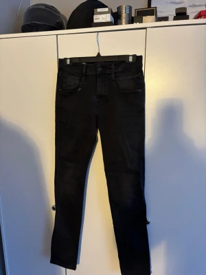 Svarta Replay jeans slim fit - Säljer ett par svarta Replay ANBASS jeans . Jeansen har slim passform, raka ben och snygga detaljer vid fickorna. Det ända täcknet på användning är den lila fläcken som ni ser på bild 2. Säljer för dom är för små för mig. Storleken är W29 L32 men efter som det är modellen ANBASS så är jeansen väldigt små. Det är bara att skriva vid funderingar. Pris kan diskuteras vid snabb affär.👍