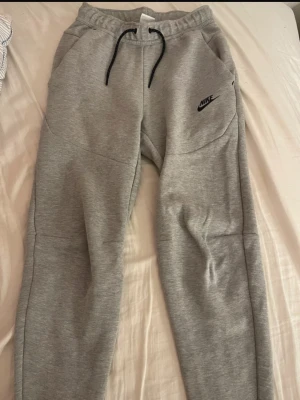 Grå mjukisbyxor från Nike XS - Gråa Nike tech byxor från Nike 