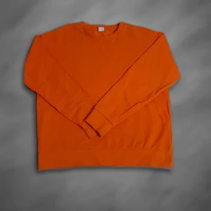 Orange sweatshirt i bomull - En stilren orange sweatshirt med rund hals och långa ärmar. Tröjan är tillverkad i mjuk bomull och har ribbade muddar vid ärmslut och nederkant. Perfekt för dig som gillar färg och vill sticka ut lite extra.