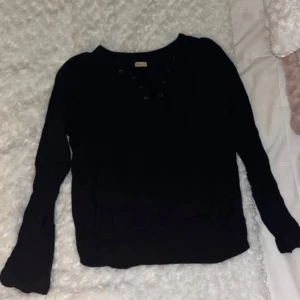 Svart långärmad tröja Hollister XS - Svart långärmad tröja från Hollister i storlek XS. Tröjan har snygg snörning framtill vid halsen och är i mjukt material. Perfekt för dig som gillar en enkel men trendig look.
