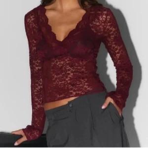 Vinröd spetsblus från Gina Tricot - Säljer en vinröd långärmad spetsblus från Gina Tricot. Blusen har v-ringning, är genombruten med blommigt spetsmönster och sitter figurnära. Perfekt för dig som vill ha en snygg och trendig topp med romantiska vibbar.🥰🥰