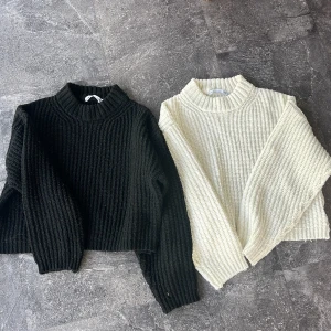 Svart och vit ribbstickad tröja 757 - Två ribbstickade tröjor från 757 i storlek 150, en svart och en vit. Båda har högre krage, croppad passform och långa ärmar. Perfekta för lager-på-lager och chill stil. Säljs tillsammans. Båda tröjorna är noppriga 