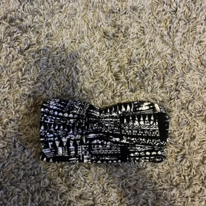 Svartvit bandeau bikini från Gina Tricot - Snygg bandeau bikiniöverdel från Gina Tricot i svartvitt grafiskt mönster. Modellen är axelbandslös och har en lätt böjd form upptill. Materialet är mjuk bomull med stretch för skön passform. Perfekt för dig som gillar stilrena och coola badkläder.