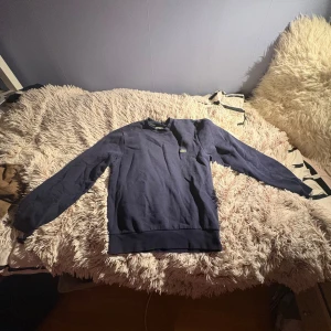 Mörkblå sweatshirt från Lacoste - En snygg marinblå Collegetröja från lacoste, mycket stilren och perfekt för vardagstillfällen eller att ha under en jacka. Extremt bra skick, knappt använd och priset är självklart diskuterbart.💸💰🪙