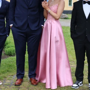 Rosa balklänning -  Säljer min fina balklänning som är sydd efter mig (168 cm lång). Klänningen är i mycket bra skick och perfekt för en bal. (Det regnade ute när bilderna tog så fläckarna på klänningen var bara vatten inget som är kvar på klänningen nu)💕  Detaljer: 	•	Färg: Candy Pink 	•	Storlek: ca 36/38 (osäker, eftersom den är skräddarsydd efter min kropp) 	•	Passform: figurnära med dragkedja bak och tunna axelband.                                  Ursprungligt pris: 5699 kr + 1000 kr för att skräddar sy den.