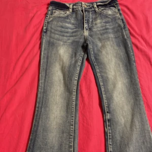 Blå bootcut jeans med detaljerade fickor - Ett par blåa bootcut jeans, har aldrig använts och har bara ligget i garderoben. Pris kan diskuteras.