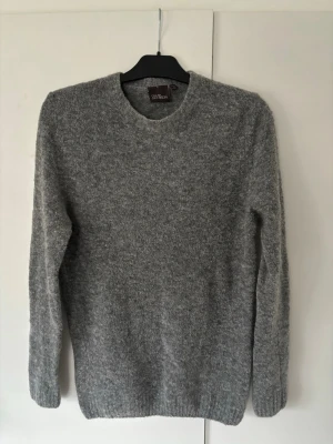 Oscar Jacobson tröja - En helt sjukt snygg stickad grå Oscar Jacobson tröja i storlek L (sitter som M) säljes. Sitter perfekt och passar till allt. Grymt skick och inga hål eller fläckar!