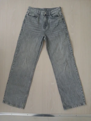 Grå wide jeans från Amisu, strl 36 - Säljer ett par gråa jeans från Amisu i storlek 36. De har en rak och loose passform med breda ben och klassisk femficksdesign. Jeansen är tillverkade i denim och har en snygg tvättad look. Perfekta till sneakers eller boots.