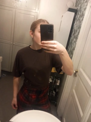 Brun t-shirt från 157, storlek XS - En basic brun t-shirt från 157 i storlek XS. T-shirten har rund halsringning och korta ärmar, perfekt för en chill och enkel stil. Tillverkad i mjuk bomull som känns skön mot huden. Passformen är normal och funkar till det mesta.