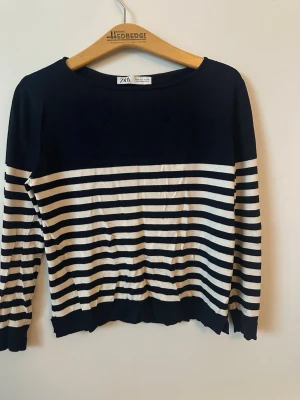 Randig långärmad tröja från ZARA - Säljer en snygg långärmad tröja från ZARA med marinblå och vita ränder. Tröjan har klassisk rund halsringning och är gjord i mjuk bomullsmix. Perfekt för dig som gillar en stilren och tidlös look.