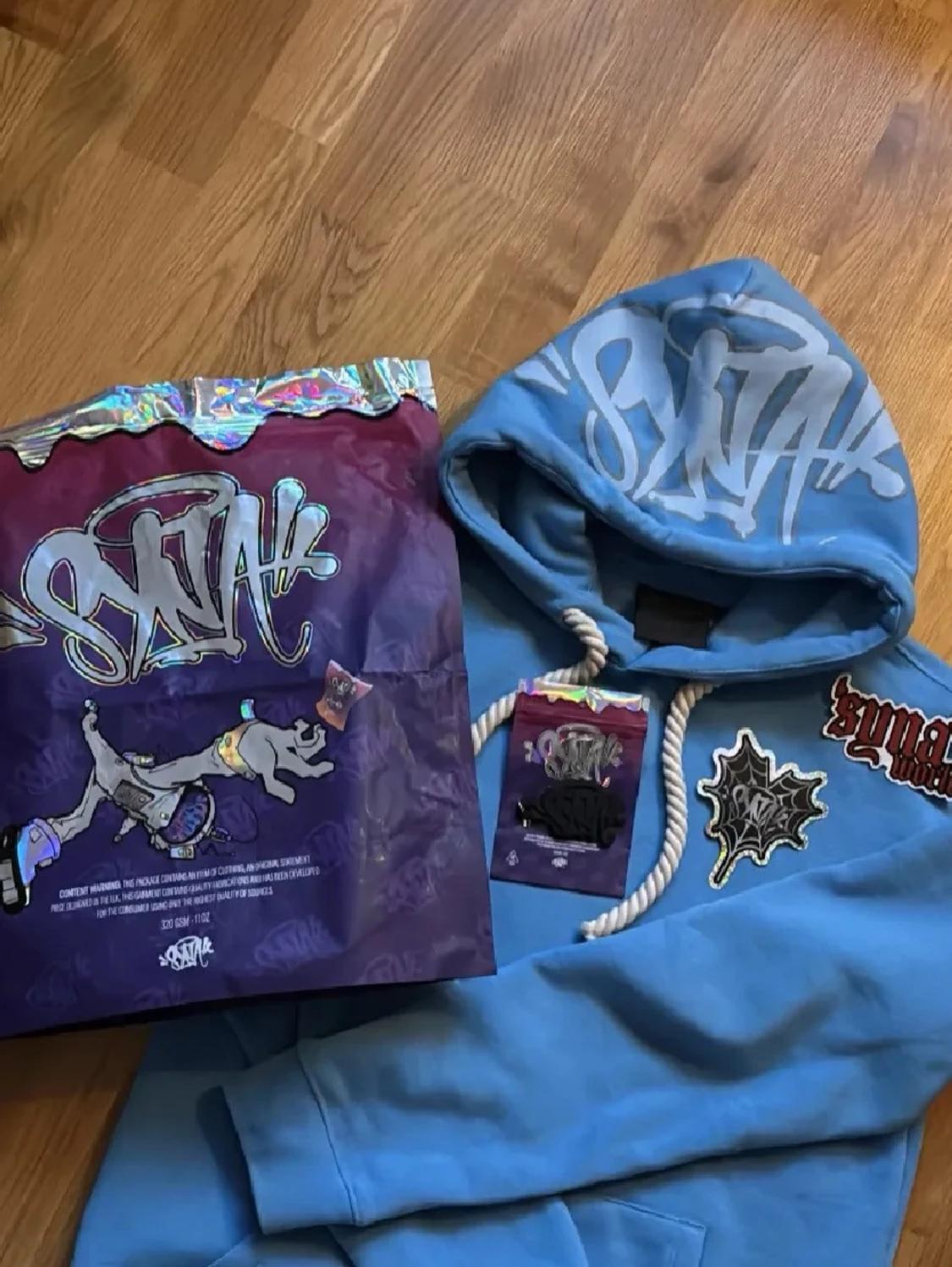 Ljusblå Streetwear Hoodie med Vit Logotyp• Trendig Ljusblå Hoodie med Graffiti-logga• Ljusblå Hoodie med Tryck på Huva• Modern Street Hoodie – Ljusblå• Casual Ljusblå Hoodie med Känguruficka - 2