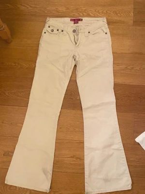 Vita lågmidjade bootcut jeans - Säljer eftersom att dem är för små på mig💕Köpt secondhand, finns några fläckar längst ner på byxorna, skriv om det finns frågor, pris kan diskuteras!💞Mått: se bilder