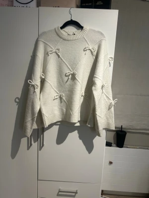 Vit stickad tröja med rosetter - Supersöt vit stickad tröja med flera små rosetter över hela tröjan. Tröjan har en rund halsringning. Jätte fin med prislapp kvar i storleken xs💗ordinarie pris 499kr