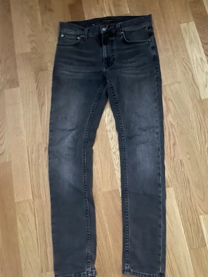 Svarta skinny jeans från Nudie Jeans - Säljer ett par svarta skinny jeans från Nudie Jeans i storlek 28/30. Jeansen har klassisk, svarta sömmar. Skön passform, modellen är Lean Dean. Bra skick