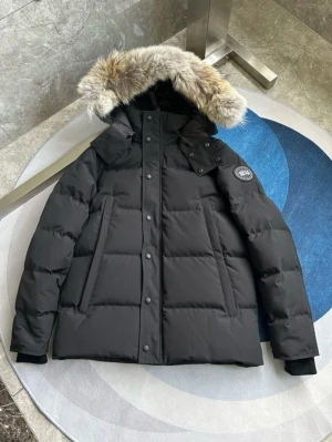  Canada Goose Wyndham  - ALLA STORLEKAR. ALLA FÄRGER. Svart dunjacka från Canada Goose med fluffig päls på huvan och broderad logotyp på ärmen. Jackan har långa ärmar, knappar och dragkedja framtill samt två sidofickor. Perfekt för kalla vinterdagar och har en riktigt schysst oversized look.