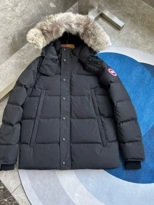 Canada Goose Wyndham jacka alla färger svart - ALLA STORLEKAR & FÄRGER! Säljer en svart dunjacka från Canada Goose med fluffig päls på huvan och klassisk logga på ärmen. Jackan har långa ärmar, dragkedja och knappar framtill samt två stora fickor. Perfekt för kalla vinterdagar och riktigt snygg stil.