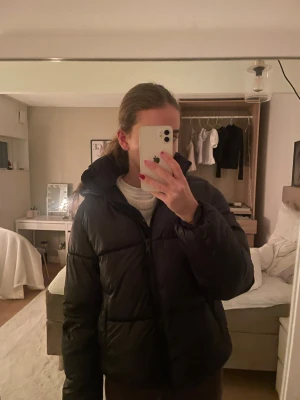 Svart pufferjacka med luva - Säljer en svart glansig/shimmrig jacka från h&m!! Jättefint skick! 