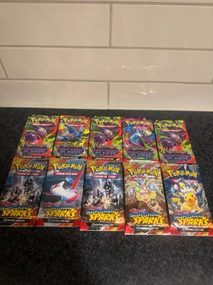 Pokémon x10 Booster Paket - Säljer 10st nya paket. Sealed. Skickas väl emballerat. 5x Phantasmal Flames & 5x Surging Sparks. 