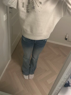 Vit stickad tröja med pärlor och paljetter - Superfin vit stickad tröja med glittriga pärlor och paljetter framtill. Tröjan har lång ärm, ribbade muddar och en lite lös passform. Perfekt för dig som vill ha något extra snyggt och mysigt till våren eller vintern. Köpt i London på forever 21. Storlek s-m används ungefär 2 gånger