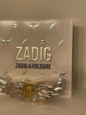 Zadig & Voltaire parfymset -  Zadig & Voltaire med unik 50ml flaska och medföljande body lotion 50ml.  Parfymen är endast test sprayad. Bodylotion är oöppnad och otestad. Köpt på notino