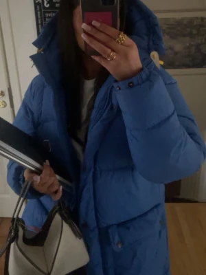Blå Expedition dunjacka från Fjällräven - Kollar intresset på min blåa Expedition Down Jacket W från Fjällräven i storlek M. Jackan är den medellånga modellen, har huva, stora fickor med knappar och gula dragkedjor. Klassisk dunjacka med broderad logga på bröstet och regular fit. Använd denna vintern, splitternytt skick, inga skador eller slitage. Nypris 10 000kr!! 