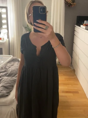 svart lång sommarklänning med snörning - svart långklänning med korta ärmar och v-ringad hals. materialet känns lätt och luftigt, perfekt för varmare dagar. finns ingen storlek på den men skulle gissa på en M.