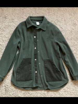 Ljusgrön Fleece Skjorta - En tunnare skjorta i fleece tyg med knappar framtill (samt knapp justering vid handleder). Mjuk och mysig som lounge wear! Sprillans ny.