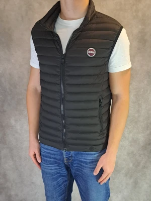 Svart Colmar Väst - Stl 48 / M - Riktigt fin Colmar Väst i färgen Svart på utsidan och turkosblått på insidan! | Skick: 8,5/10, en liten lagning med en lagninglapp ( Se bild 5 ), inget som direkt märks av vid användning | Modellen är 175cm men sitter lite tight, rekommenderar att du är mellan 164-175cm lång, för säkerhets skull dubbelkolla Colmars egna mått ( Se sista bilden )