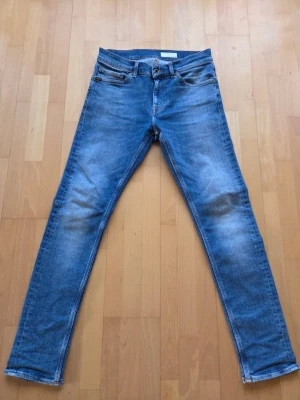 Blå skinny jeans Tiger of Sweden - Säljer ett par blå skinny jeans från Tiger of Sweden. Klassisk femficksmodell med snygga slitningar och kontrastsömmar. Jeansen har normal passform i midjan och smala ben. Perfekta till sneakers eller boots. W28 L32