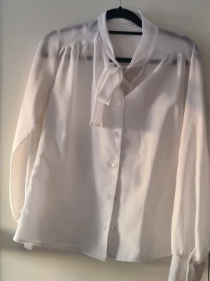 Vinetta Knytblus - Retro knytblus i vitt, snygg och stilren. Dock lite genomskinlig som bilden visar.