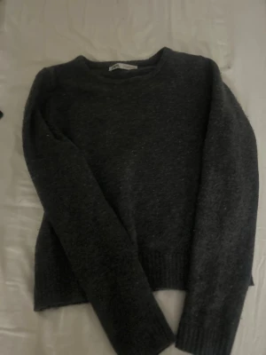 Mörkgrå stickad tröja från Zara - Säljer en enkel och snygg mörkgrå stickad tröja från Zara i storlek S. Tröjan har rund hals, långa ärmar och ribbade muddar vid ärmslut och nederkant. Perfekt för kyliga dagar och passar till jeans eller kjol. Tröjan är originellt köpt för 500 så följer därför den för 250 eftersom att den e i ganska bra skick