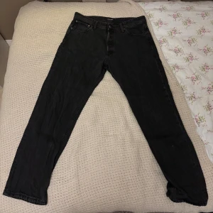 Svarta relaxed jeans Jack & Jones - Svarta jeans från Jack & Jones i modellen Relaxed/Chris. Klassisk femficksdesign, raka ben och normal passform. Jeansen är tillverkade i denim och har bälteshällor samt knappgylf. Perfekta för en avslappnad stil. 34W, 32L