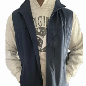 Mörkblå väst - Riktigt snygg väst som funkar som windbreaker. Aldrig använd och perfekt skick. Storlek XS men sitter mer som S