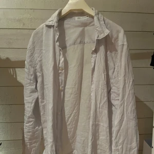 Ljusblå linneskjorta från Zara - Säljer en stilren ljusblå skjorta från Zara i mjukt linne. Skjortan har klassisk krage, knappar framtill och långa ärmar. Perfekt för dig som gillar en clean och chill look. Passar dig som vill ha något enkelt men ändå snyggt. Helt oanvänd