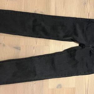 Svarta slim jeans från 157, stl 160 - Svarta jeans från 157 i modellen Slimmy Star. Klassisk femficksdesign, smal passform och raka ben. Jeansen är tillverkade i bomullsmix och har en stilren look som passar till det mesta. Perfekta för dig som gillar en enkel och clean stil.