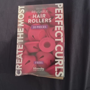 Blossity hårrollers 20-pack rosa - Säljer ett set med 20 återanvändbara hårrollers från Blossity. Rollersen är rosa och kommer i två olika storlekar för både stora och små lockar. De är enkla att använda och kan lämnas i håret över natten. Perfekt för dig som vill fixa snygga curls hemma. Köpte i Italien i somras men har för tjockt hår så kan ej använda. 