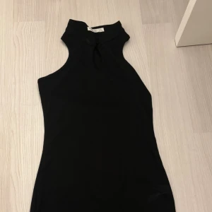 Svart ribbad klänning från Shein Teen - Svart, tight ribbad klänning från Shein Teen med medelhög hals och ärmlös design. Klänningen har en liten öppning framtill vid halsen och är i kort modell. Perfekt för dig som gillar en enkel men stilren look. Pris kan diskuteras!