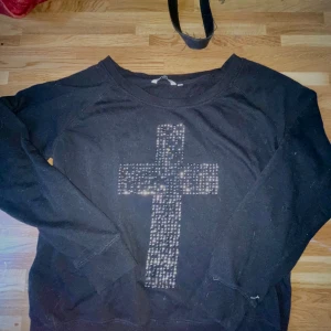 Tröja kors nitar - Långärmad tröja med nitat kors. Några nitar har ramlat av