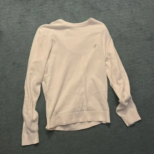 Vit långärmad tröja från Pier One - Snygg vit långärmad tröja från Pier One med rund hals och diskret broderad fågel på bröstet. Tröjan är gjord i mjuk bomull och har ribbad kant vid halsen samt klassisk passform. Perfekt för dig som gillar stilrena och enkla plagg.