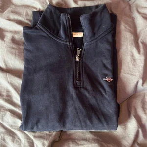 Marinblå half zip tröja från Gant - Marinblå långärmad tröja från Gant med halv dragkedja och har hög krage. 
